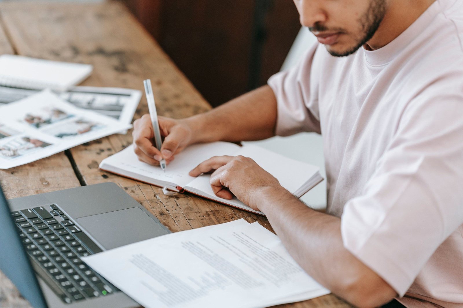 Dirigeant prenant des notes à son bureau, devant son ordinateur